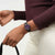 Dunkelbraune Armbanduhr am Handgelenk mit violettem Zifferblatt und „FRI 28“