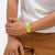 Damenuhr am Handgelenk mit leuchtend gelbem transparentem Armband und gut sichtbaren Zeigern