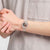 Transparente Armbanduhr am Handgelenk, sichtbares Uhrwerk und mehrfarbige Zeiger