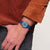Damenarmbanduhr am Handgelenk: blaues Zifferblatt und dunkelblaues Silikonband.