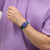 Swatch Armbanduhr am Handgelenk, dunkelgrün, blaues Zifferblatt mit Datum „FRI 28“