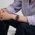 Armbanduhr am Handgelenk mit burgunderfarbenem Silikonarmband und dunklem Zifferblatt