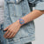 Swatch-Armbanduhr am Handgelenk mit transparentem Gehäuse und buntem Kunstdruck-Zifferblatt
