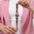 Damenuhr mit rundem Zifferblatt und buntem Armband, rosa Akzenten, Kunststoffgehäuse