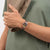 Damenuhr am Handgelenk mit rosafarbenem Gehäuse und gemustertem Armband