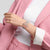 Runde Armbanduhr mit rosafarbenem Armband und hellem Zifferblatt