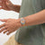 Swatch Armbanduhr am Handgelenk mit buntem transparentem Kunststoffarmband und rundem Ziffernblatt