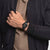 Schwarze Swatch Armbanduhr am Handgelenk mit schwarzem Armband und Werkansicht