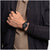 Schwarze Swatch Armbanduhr am Handgelenk mit Sicht auf das Uhrwerk