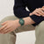 Swatch Armbanduhr am Handgelenk, grünes Zifferblatt mit offenem Design