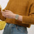 Beige Armbanduhr am Handgelenk, rundes Glas, silbernes Band und rote Markierungen