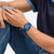Swatch Armbanduhr blau am Handgelenk, rundes Zifferblatt mit Streifenmuster