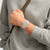 Swatch Armbanduhr auf dem Handgelenk, transparentes Gehäuse, Zifferblatt mit Linienmotiv