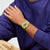 Swatch Armbanduhr am Handgelenk mit gelbem Musterband und pinken Zeigern