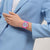 Armbanduhr von Swatch am Handgelenk mit pinkem Armband und buntem Zifferblatt