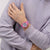 Swatch Armbanduhr am Handgelenk mit pinkem Armband und rundem Zifferblatt