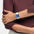 Swatch Armbanduhr getragen: quadratische Uhr mit blauem Zifferblatt und beigem Armband