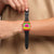 Swatch Armbanduhr am Handgelenk: orangefarbenes Gehäuse, schwarzes Band, pinkes Zifferblatt