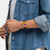 Swatch Armbanduhr am Handgelenk, orangefarbenes Gehäuse, schwarzes Band