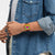 Swatch Armbanduhr am Handgelenk, orangefarbenes Gehäuse, schwarzes Band