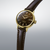 Montre pour femme avec bracelet en cuir marron et boîtier rond doré, cadran marron foncé