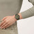 Swatch Armbanduhr am Handgelenk mit dunkelgrünem Zifferblatt und olivgrünem Armband