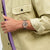 Armbanduhr am Handgelenk, Roségoldfarbenes Gehäuse mit offenem Uhrwerk, dunkles Violettband.