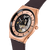 Armbanduhr in Schrägsicht: Roségoldfarbenes Gehäuse, offen sichtbares Uhrwerk, violettes Band.