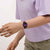 Swatch Damenuhr am Handgelenk: violettes Zifferblatt, schwarzes gemustertes Armband