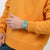 Damenuhr am Handgelenk mit türkis-grünem Armband und lila Zeigern