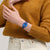 Armbanduhr am Handgelenk: blaues Zifferblatt mit türkisfarbenem Innenring, blaues Band.