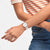 Swatch Armbanduhr am Handgelenk mit rundem weißem Zifferblatt und weißem Band