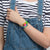 Neon-Armbanduhr am Handgelenk: rundes Zifferblatt mit buntem Gehäuse und Armband