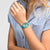 Swatch Damenuhr Pastell-Teal am Handgelenk, klares Zifferblatt mit pinkem Zeiger