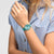 Swatch Damenuhr Pastell-Teal am Handgelenk, rundes Zifferblatt mit pinkem Zeiger