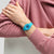 Damenuhr am Handgelenk mit türkisfarbenem Silikonarmband und blauem Zifferblatt