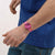 Swatch Damenuhr am Handgelenk am Armärmel mit pinkem Armband und Zifferblatt