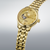 Montre homme avec cadran doré et bracelet en métal doré, vue de biais