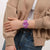 Swatch Damenarmbanduhr am Handgelenk, violettes Ziffernblatt und Armband mit weißem Akzent