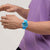 Blaue Armbanduhr am Handgelenk mit blauem Armband und leuchtenden Zeigern