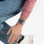 Trageansicht: Swatch-Armbanduhr mit rundem Zifferblatt und farbigem Kunstmotiv am Handgelenk.