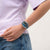Armbanduhr mit transparentem Gehäuse und buntem Zifferblatt am Handgelenk
