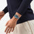 Armbanduhr am Handgelenk mit blauem Spritzdesign auf transparentem Armband
