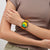 Armbanduhr am Handgelenk: orangefarbenes Band, grün-oranges Zifferblatt mit Chronographanzeige