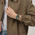 Handgelenkaufnahme einer Camouflage-Chronographenarmbanduhr: grünes Band, orangefarbene Details