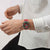 Tragende Armbanduhr am Handgelenk: rotes Armband, grünes Zifferblatt mit Chrono-Details