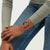 Swatch Armbanduhr am Handgelenk zu Jeans, orangefarbenes Band und dunkelblaues Chronograph-Zifferblatt