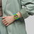 Herren-Armbanduhr am Handgelenk mit blau-grünem Kunststoffband und gelbem Chronograph