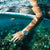 Damenarmbanduhr am Handgelenk im Wasser: helles Lederband, goldfarbenes Gehäuse, blaues Zifferblatt