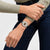 Swatch Armbanduhr am Handgelenk: braunes Zifferblatt, schwarzes Band, silbernes Gehäuse.